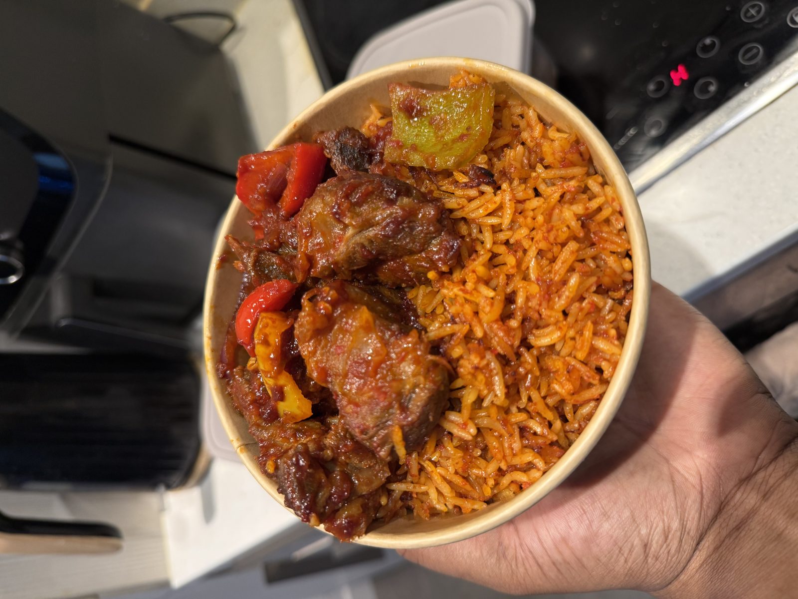Bowl of jollof rice with peppered goat meat